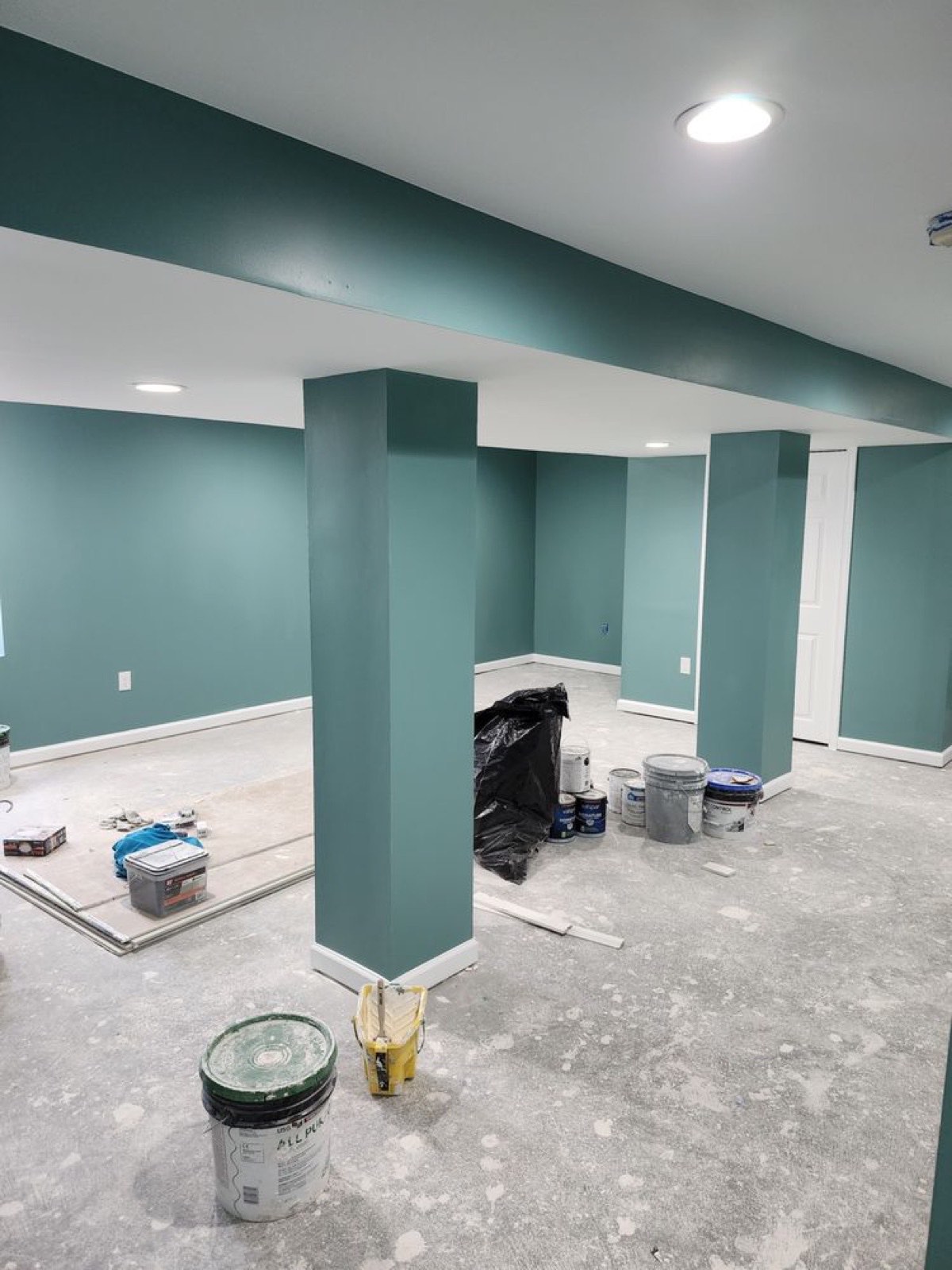 Refinished basement painted in deep teal