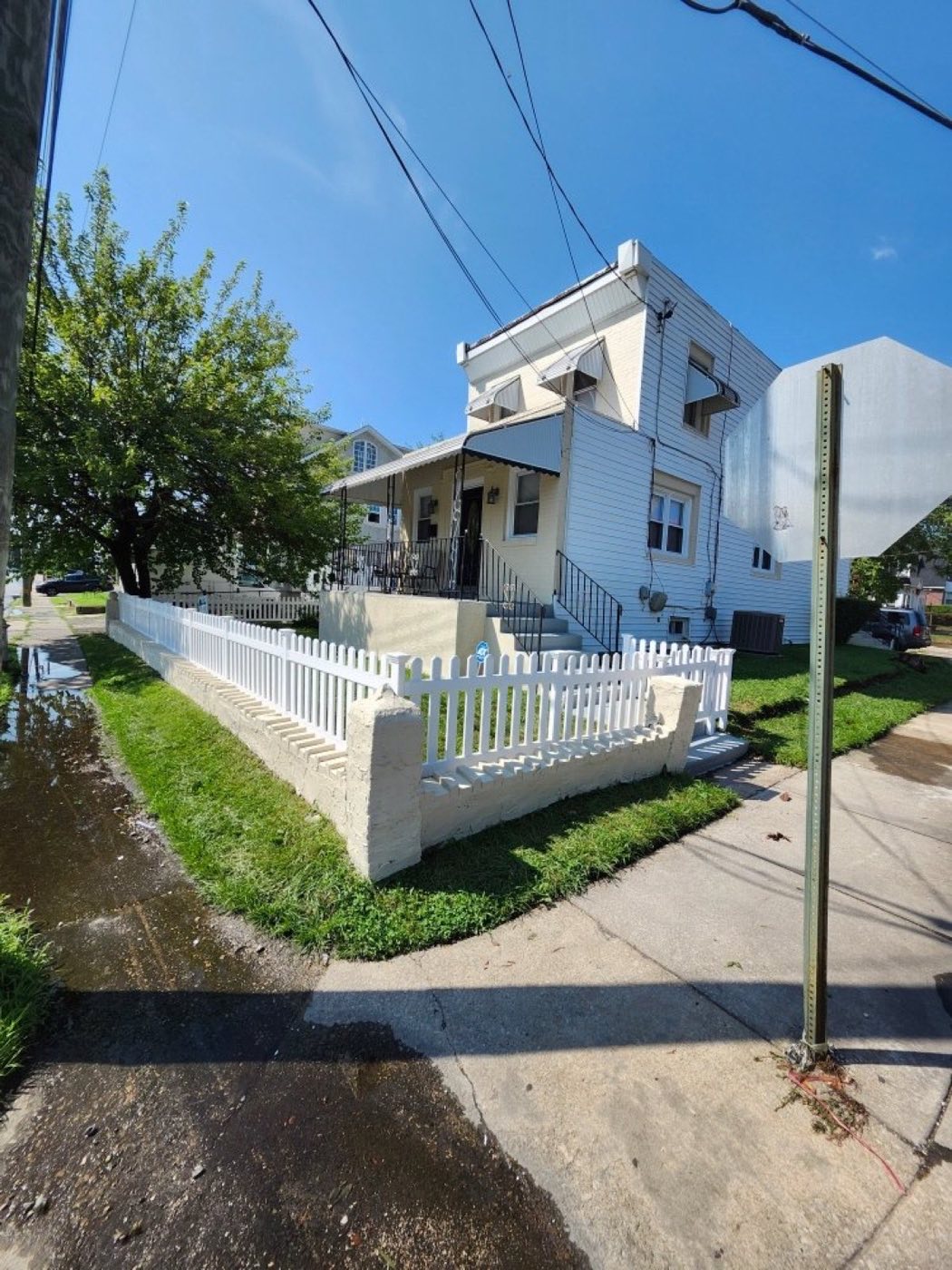Home exterior with new white picket fence and railing work