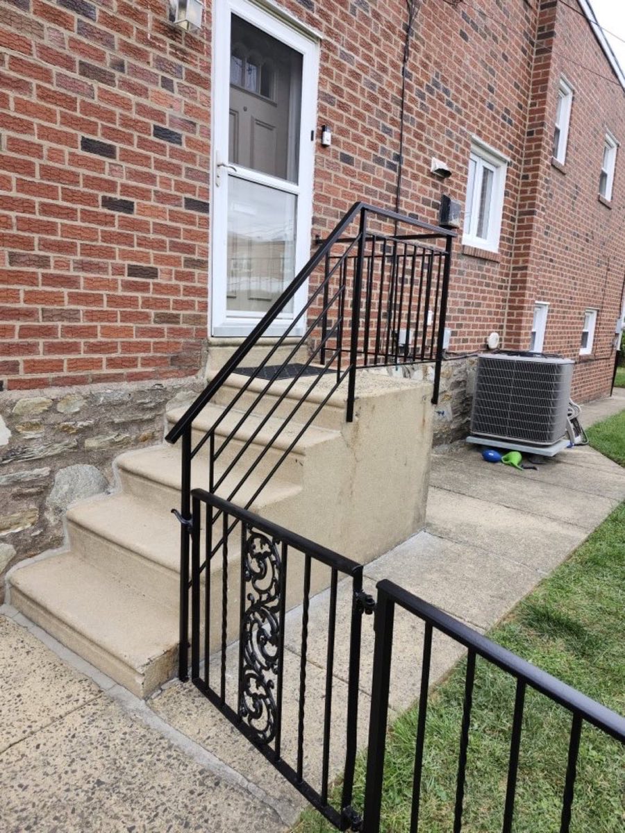 Custom black iron railing on brick front steps